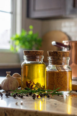 Spices and oils on a kitchen counter with a pot in the background